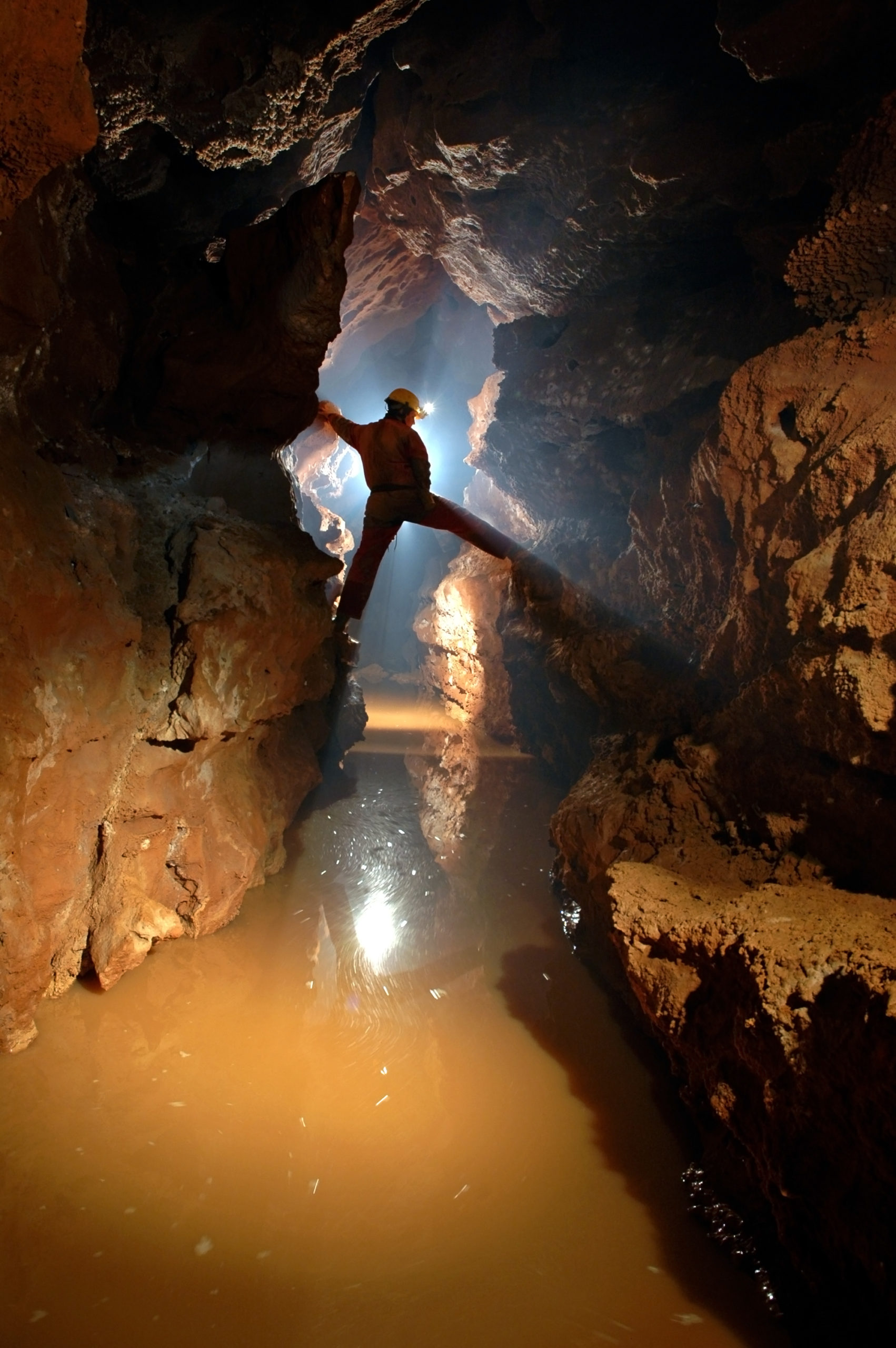 Silhouette of a cave explorer in the underground exploring a cave